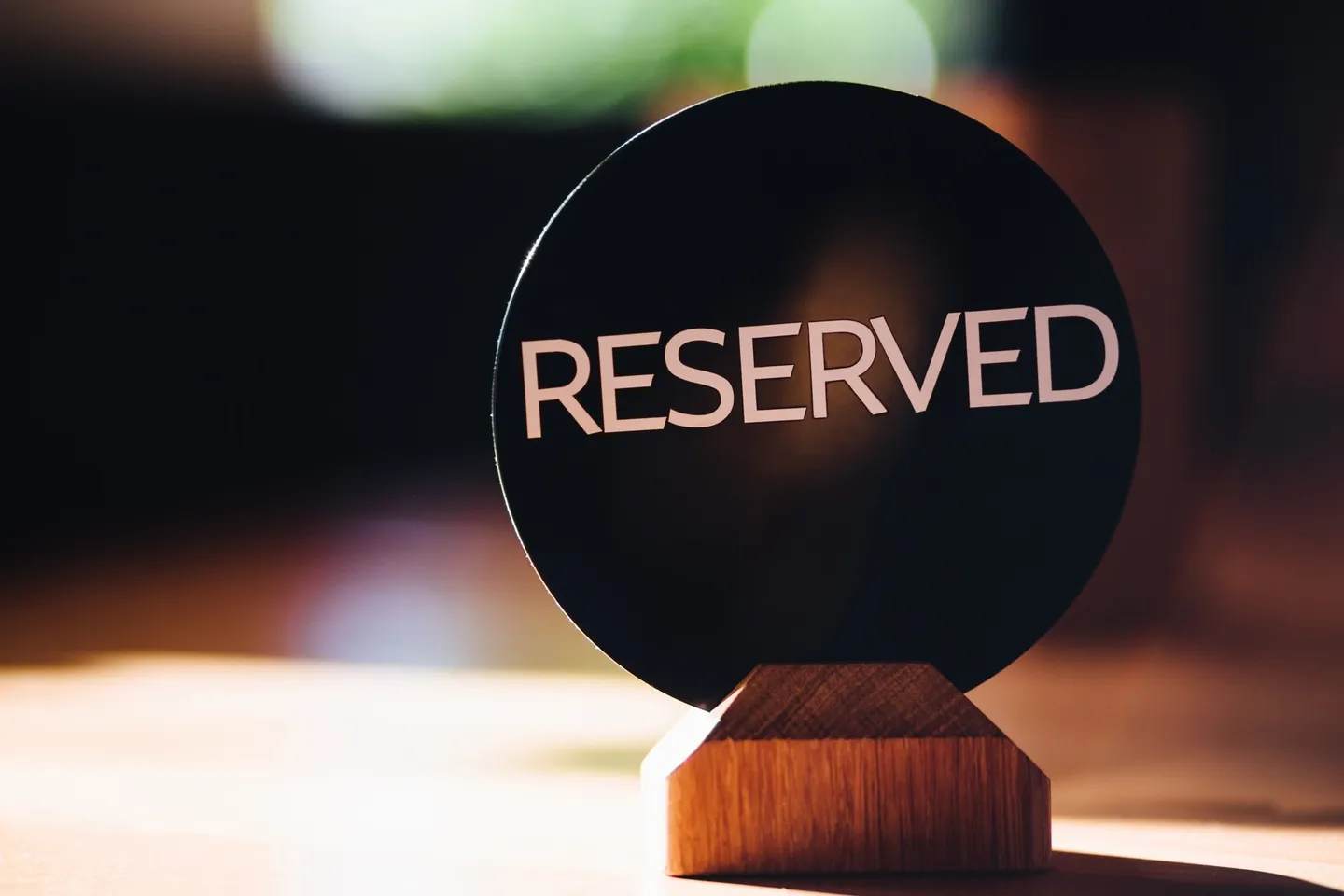 A sign that says reserved on top of a wooden stand.